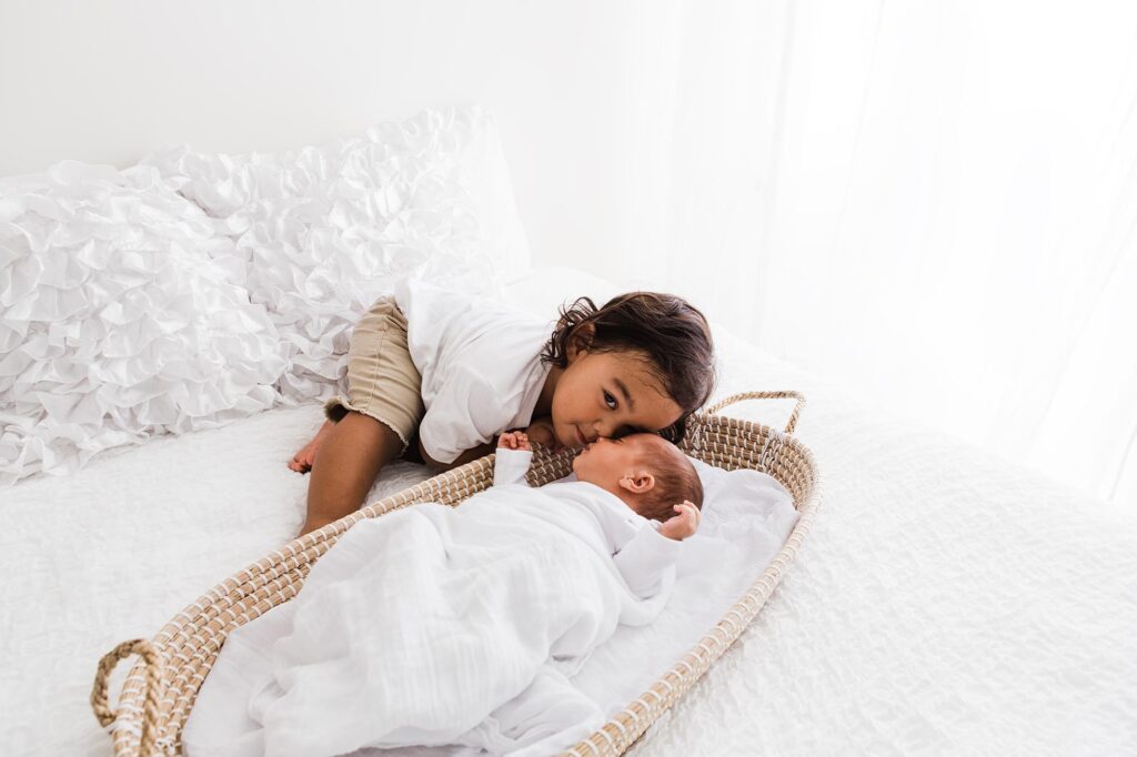 Newborn baby and older brother nose to nose during newborn photoshoot in Abu Dhabi