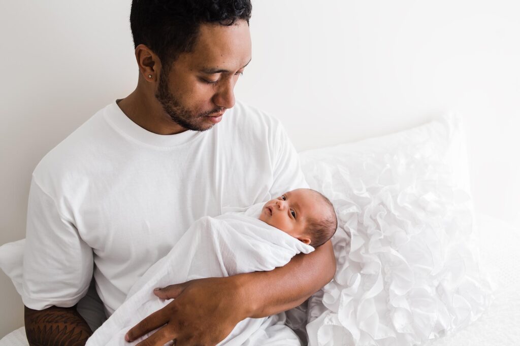 Newborn baby held in fathers arms.