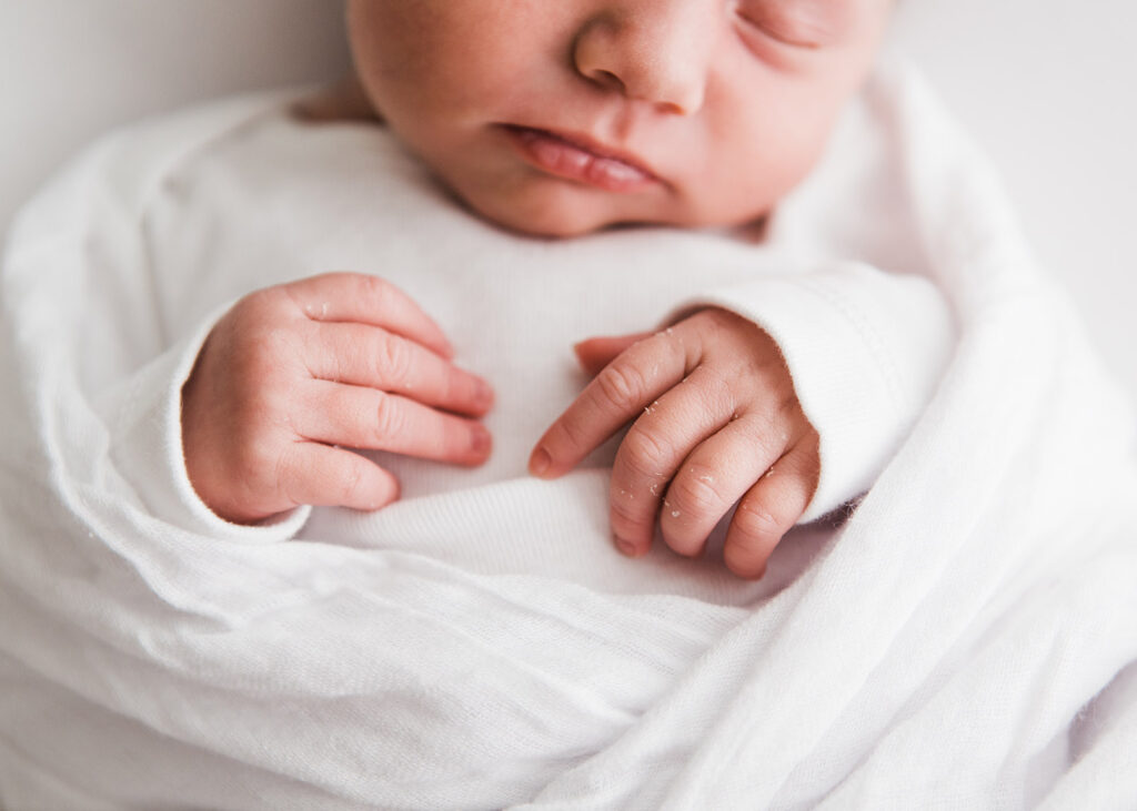 Macro image of newborn baby hands taken during newborn photoshoot.