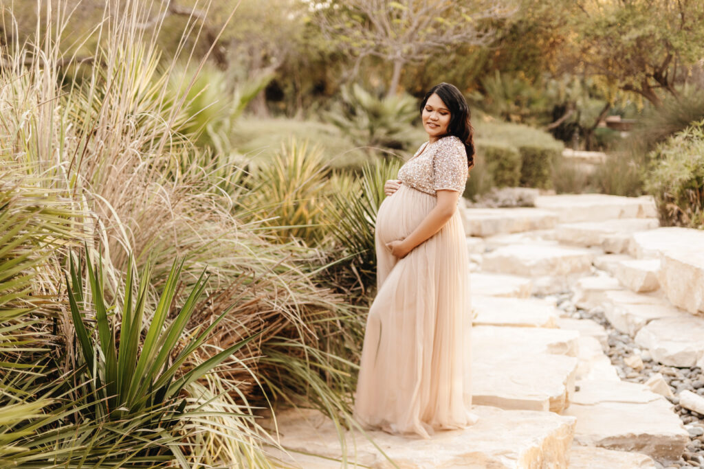 Pregnant mother posing in front of native grasses during a maternity photo shoot at Umm Al Emarat Park in Abu Dhabi. 